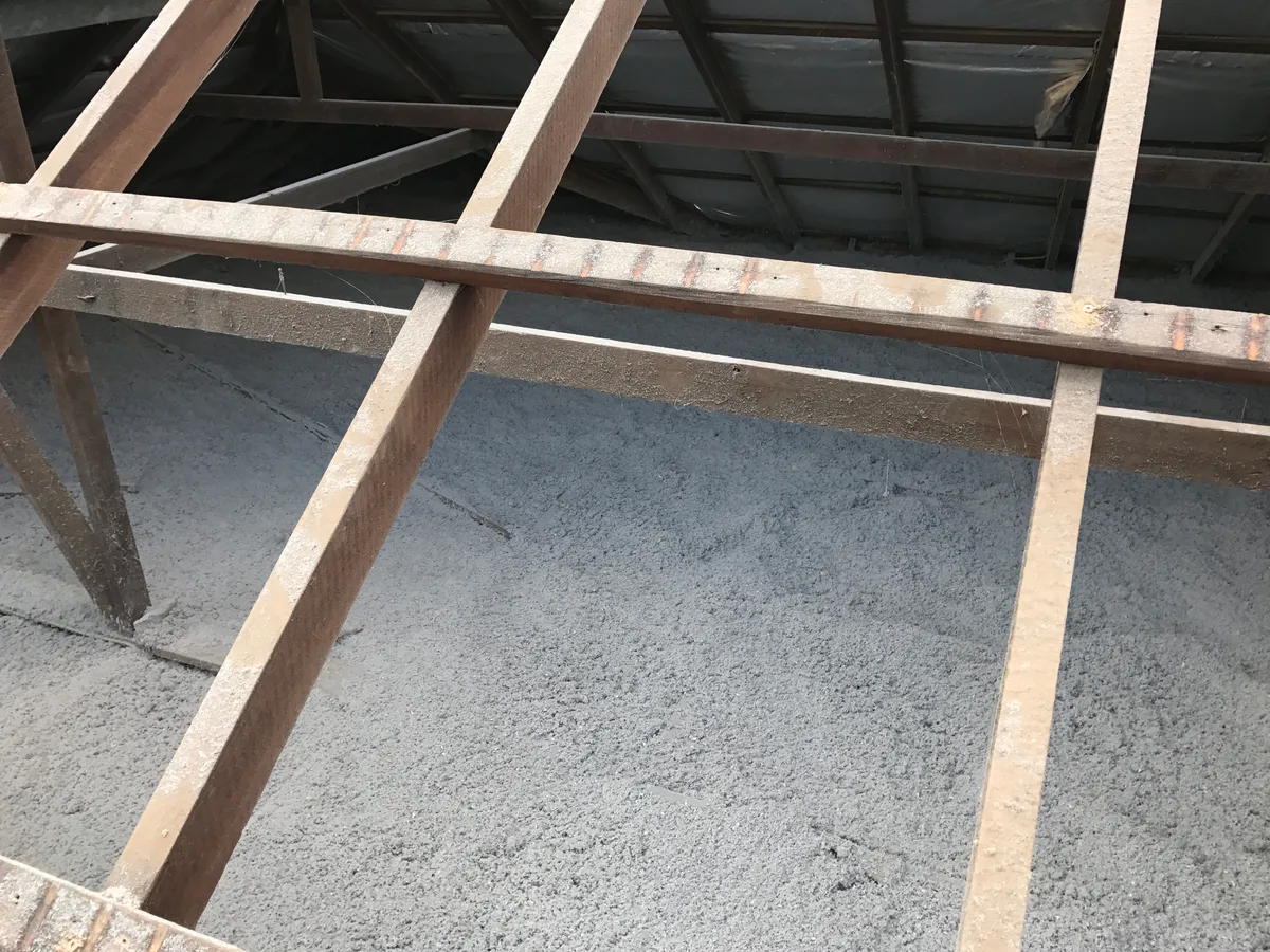 A seamless grey blanket of pumped-in cellulose fibre insulation filling the ceiling evenly between the timber joists — Jimboomba